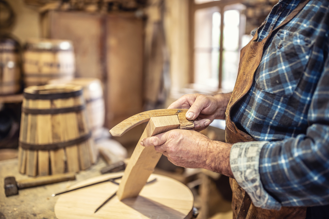 Detail Of Old Man's Hands Gathering Parts For A Wooden Barrel Assembly.